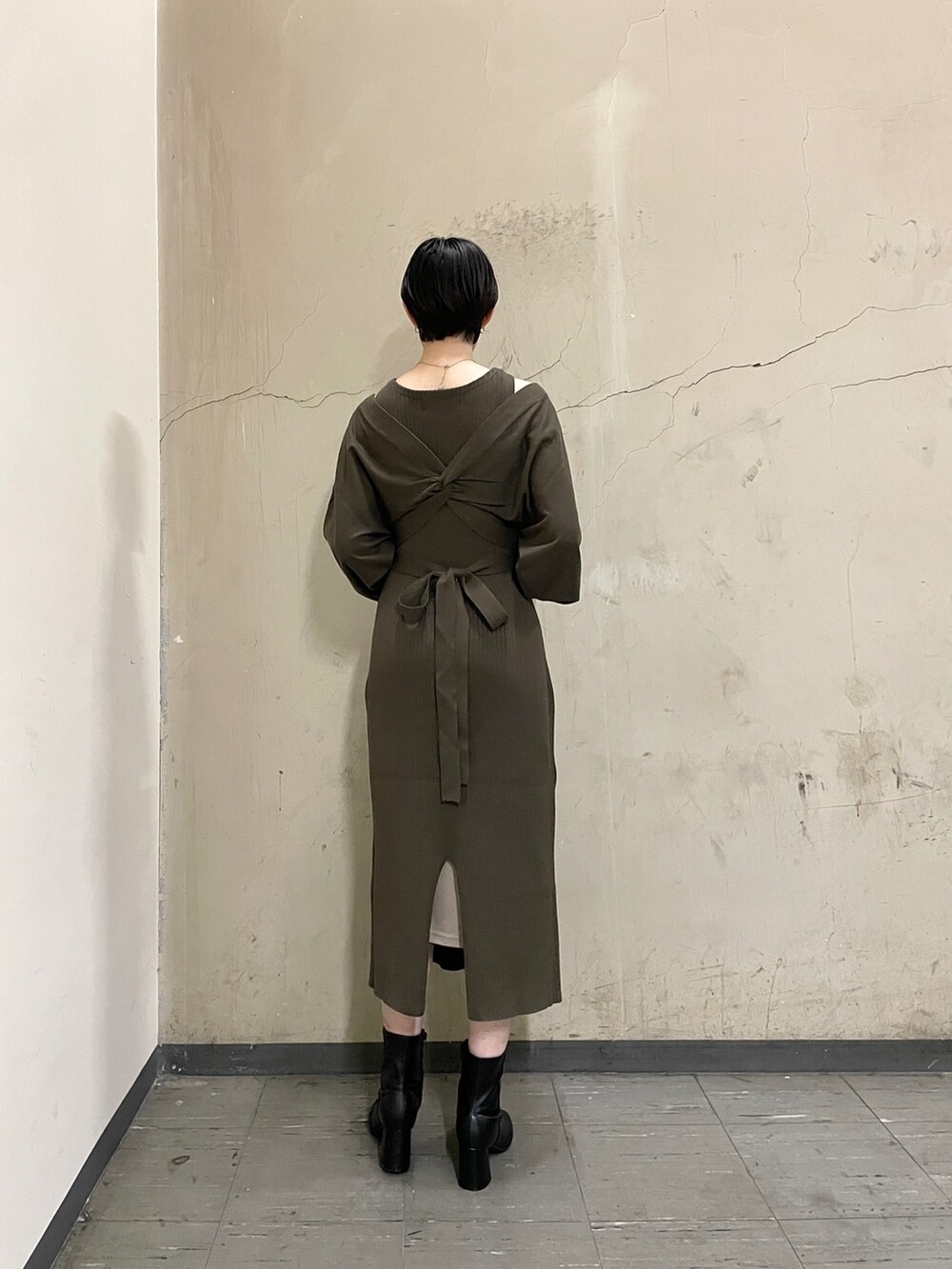 ブラウン系のワンピース、ブラック系のブーツ、ホワイト系のハンドバッグを着用したレディースの秋コーディネートの4枚目の写真