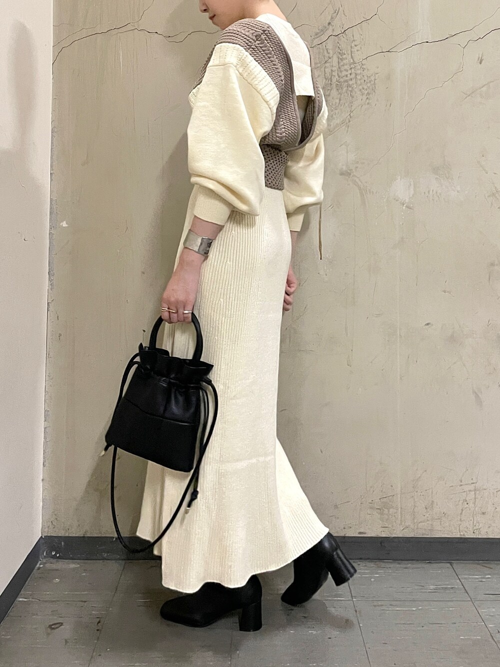 ホワイト系のワンピース、ブラック系のブーツ、ブラック系のハンドバッグを着用したレディースの秋コーディネートの4枚目の写真
