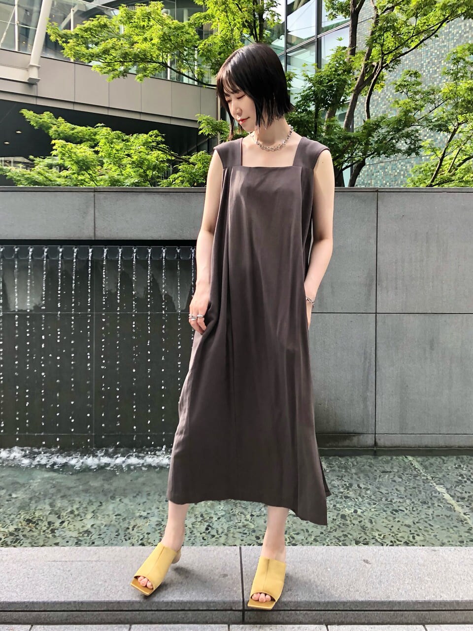 イエロー系のサンダル、グレー系のワンピース、シルバー系のネックレスを着用したレディースの夏コーディネートの5枚目の写真