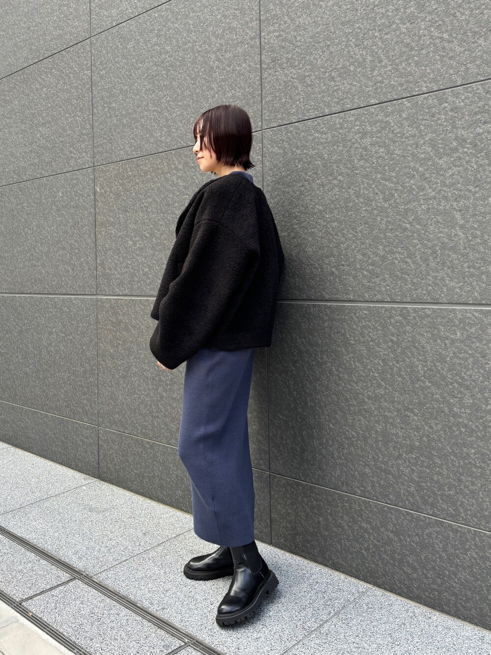 ブルー系のワンピース、ブラック系のブルゾンを着用したレディースの秋コーディネートの3枚目の写真