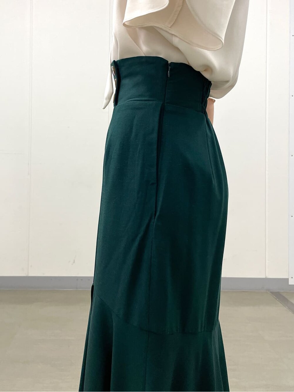 ホワイト系のシャツ/ブラウス、グリーン系のスカート、ブラック系のブーツを着用したレディースの秋コーディネートの8枚目の写真