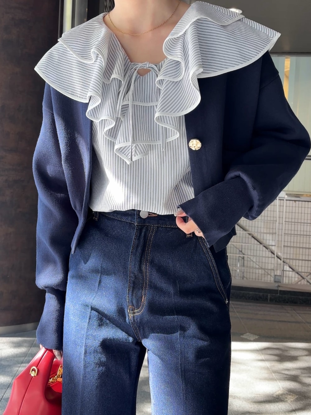 ホワイト系のシャツ/ブラウス、ブルー系のカーディガン/ボレロ、レッド系のハンドバッグを着用したレディースの冬コーディネートの7枚目の写真