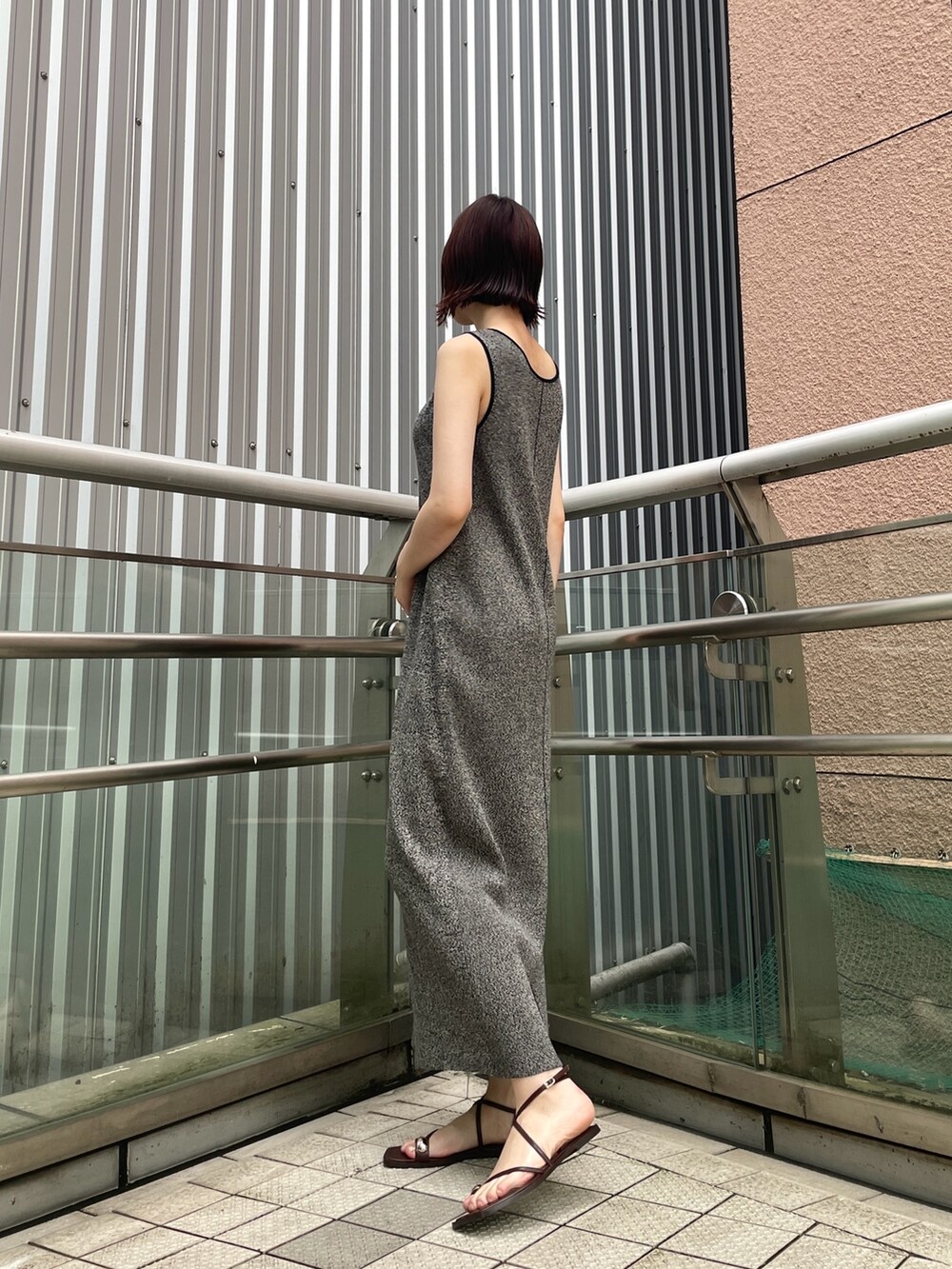 ブラウン系のサンダル、ブラック系のワンピースを着用したレディースの夏コーディネートの4枚目の写真