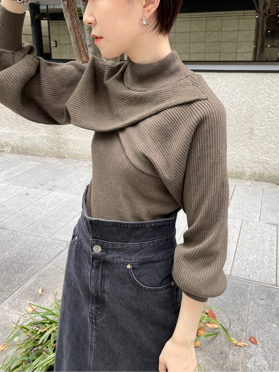 ベージュ系のニット/セーター、ホワイト系のハンドバッグ、ブラック系のデニムスカートを着用したレディースの冬コーディネートの8枚目の写真