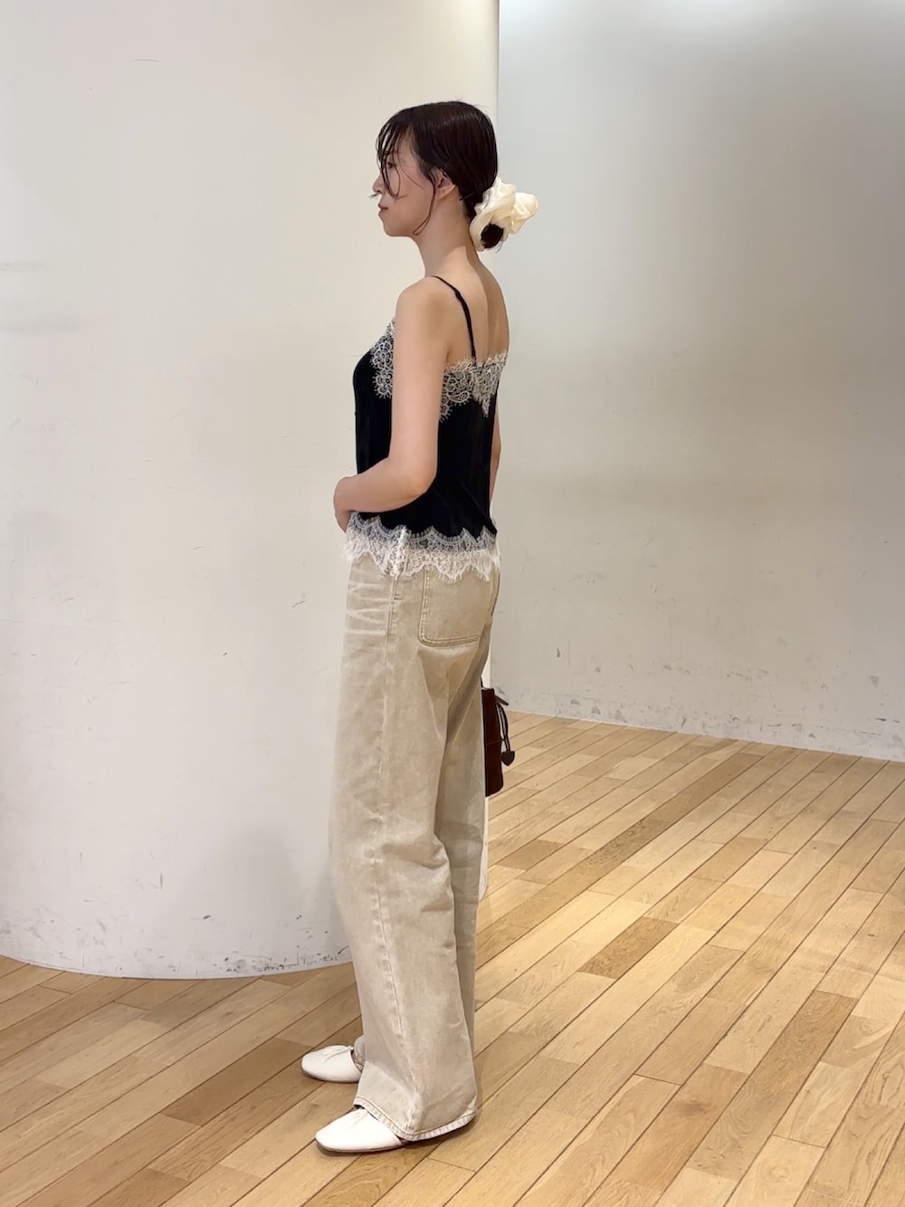 ベージュ系のデニムパンツ、ブラック系のTシャツ/カットソー、ブラウン系のハンドバッグを着用したレディースの夏コーディネートの2枚目の写真