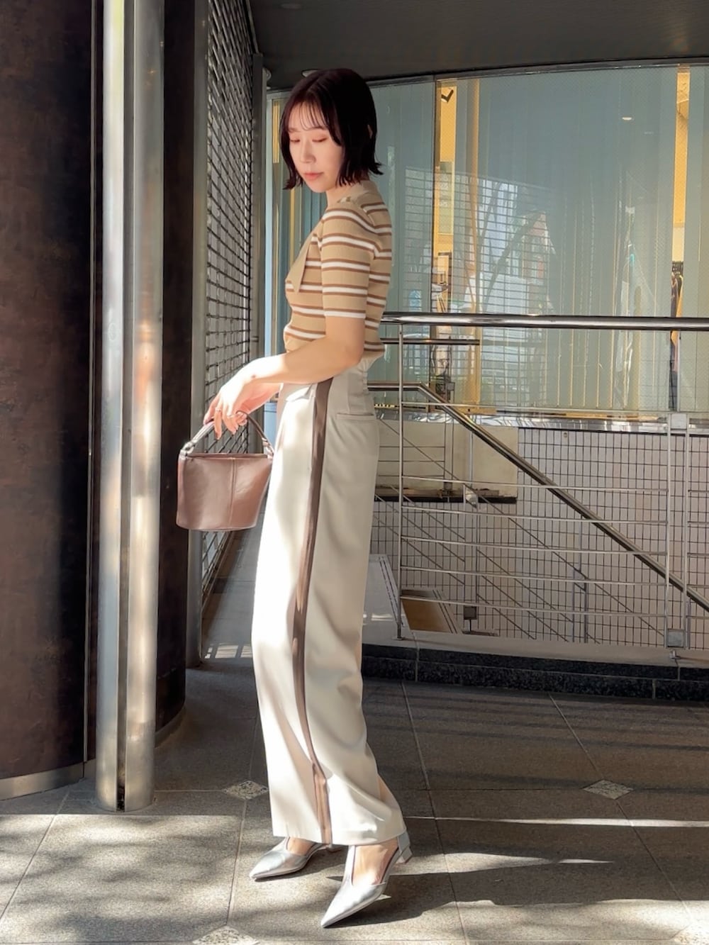 ホワイト系のその他パンツ、シルバー系のパンプス、ブラウン系のハンドバッグを着用したレディースの冬コーディネートの4枚目の写真