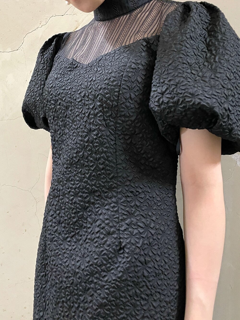 ブラック系のドレス、ゴールド系のハンドバッグ、ゴールド系のパンプスを着用したレディースの秋コーディネートの8枚目の写真