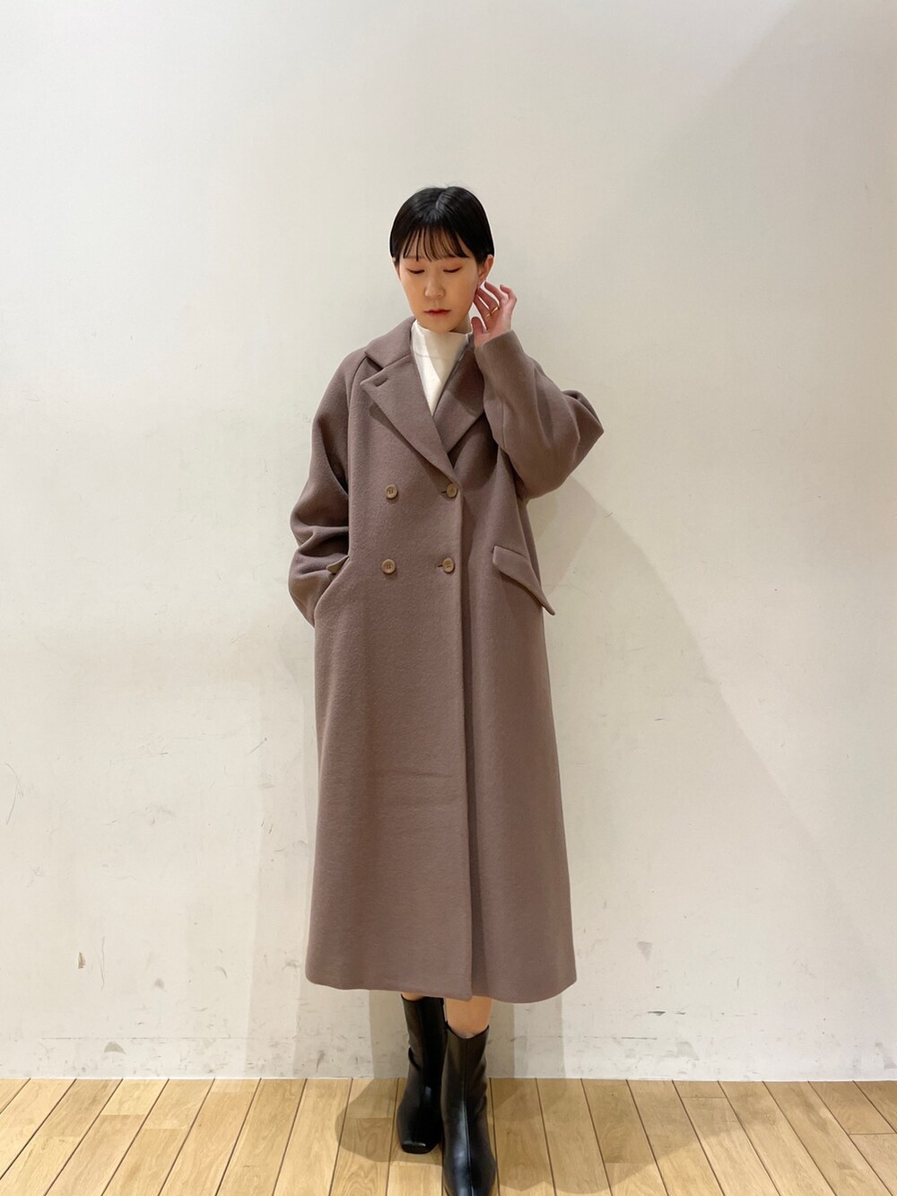 ホワイト系のニット/セーター、ブラック系のスカート、ブラック系のブーツを着用したレディースの冬コーディネートの6枚目の写真