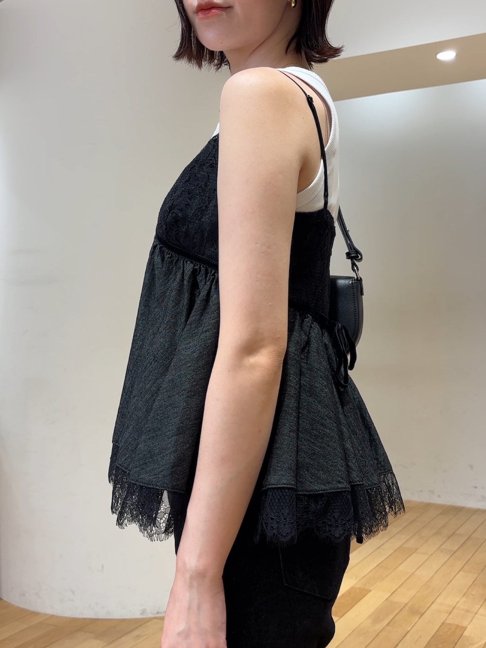 ブラック系のデニムパンツ、シルバー系のパンプス、ホワイト系のタンクトップを着用したレディースの夏コーディネートの6枚目の写真
