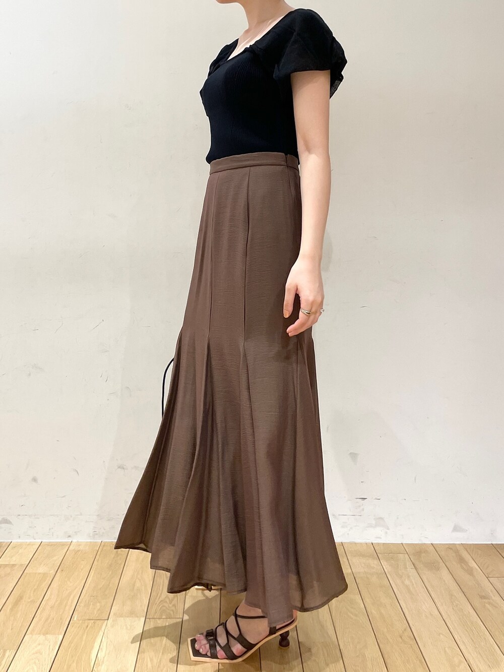 ブラウン系のスカート、ブラウン系のサンダル、ブラック系のハンドバッグを着用したレディースの夏コーディネートの5枚目の写真