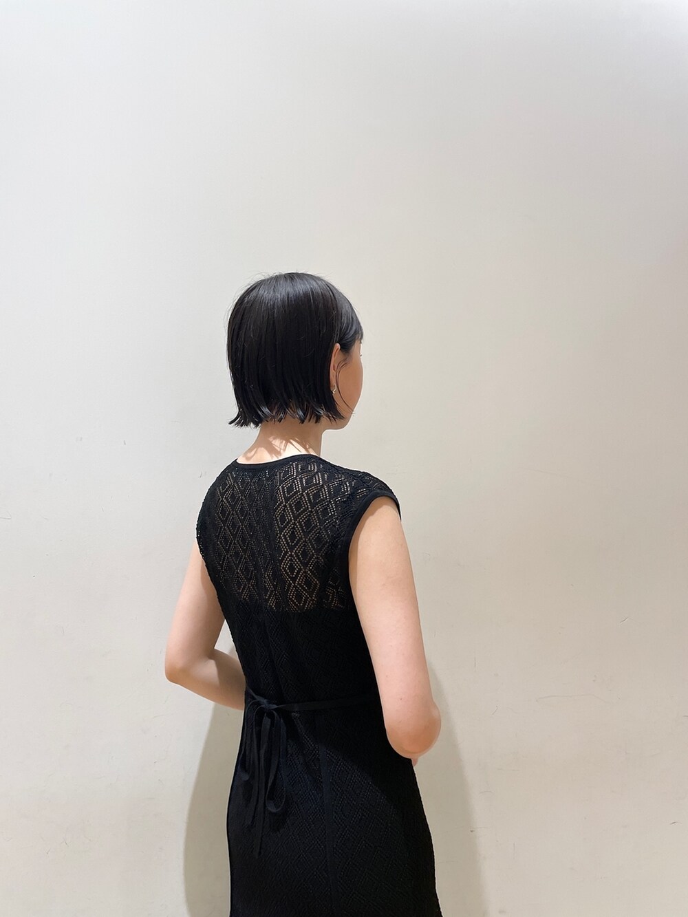 ブラック系のワンピース、ブラック系のハンドバッグ、ブラウン系のサンダルを着用したレディースの夏コーディネートの8枚目の写真