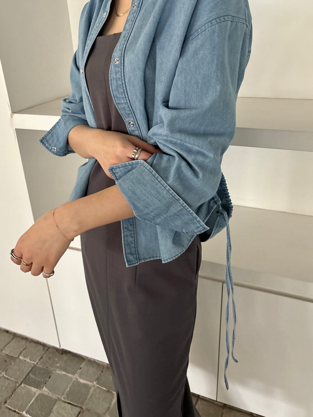 グレー系のワンピース、ホワイト系のサンダル、ブルー系のシャツ/ブラウスを着用したレディースの冬コーディネートの7枚目の写真