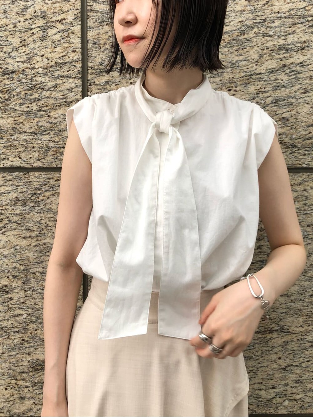 ホワイト系のシャツ/ブラウス、ホワイト系のスカート、オレンジ系のスリッポンを着用したレディースの夏コーディネートの6枚目の写真