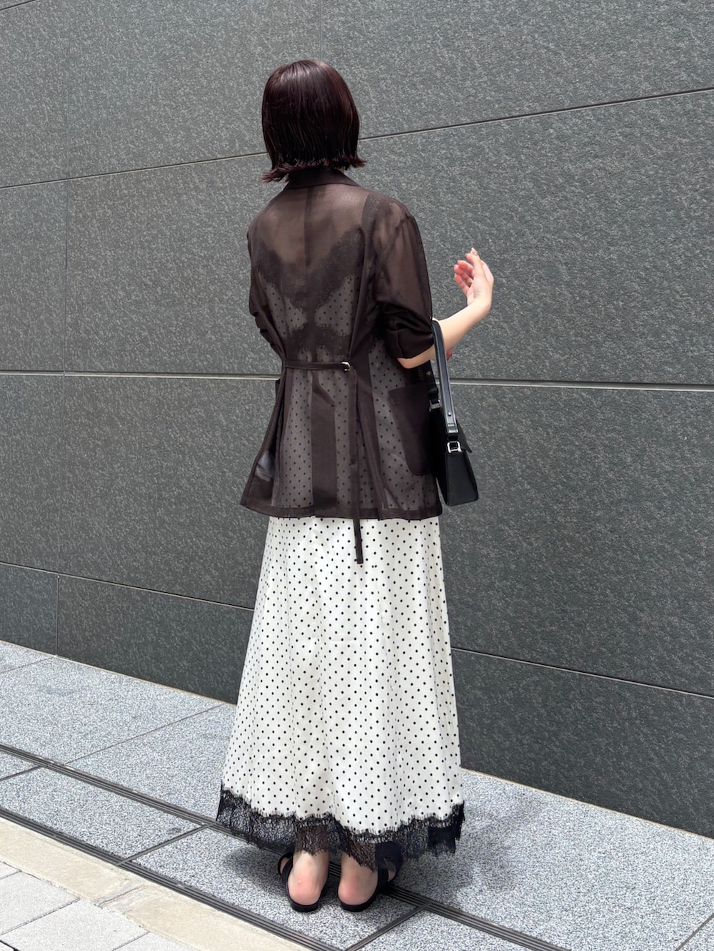 ホワイト系のワンピース、ブラック系のハンドバッグ、ブラウン系のサンダルを着用したレディースの夏コーディネートの9枚目の写真