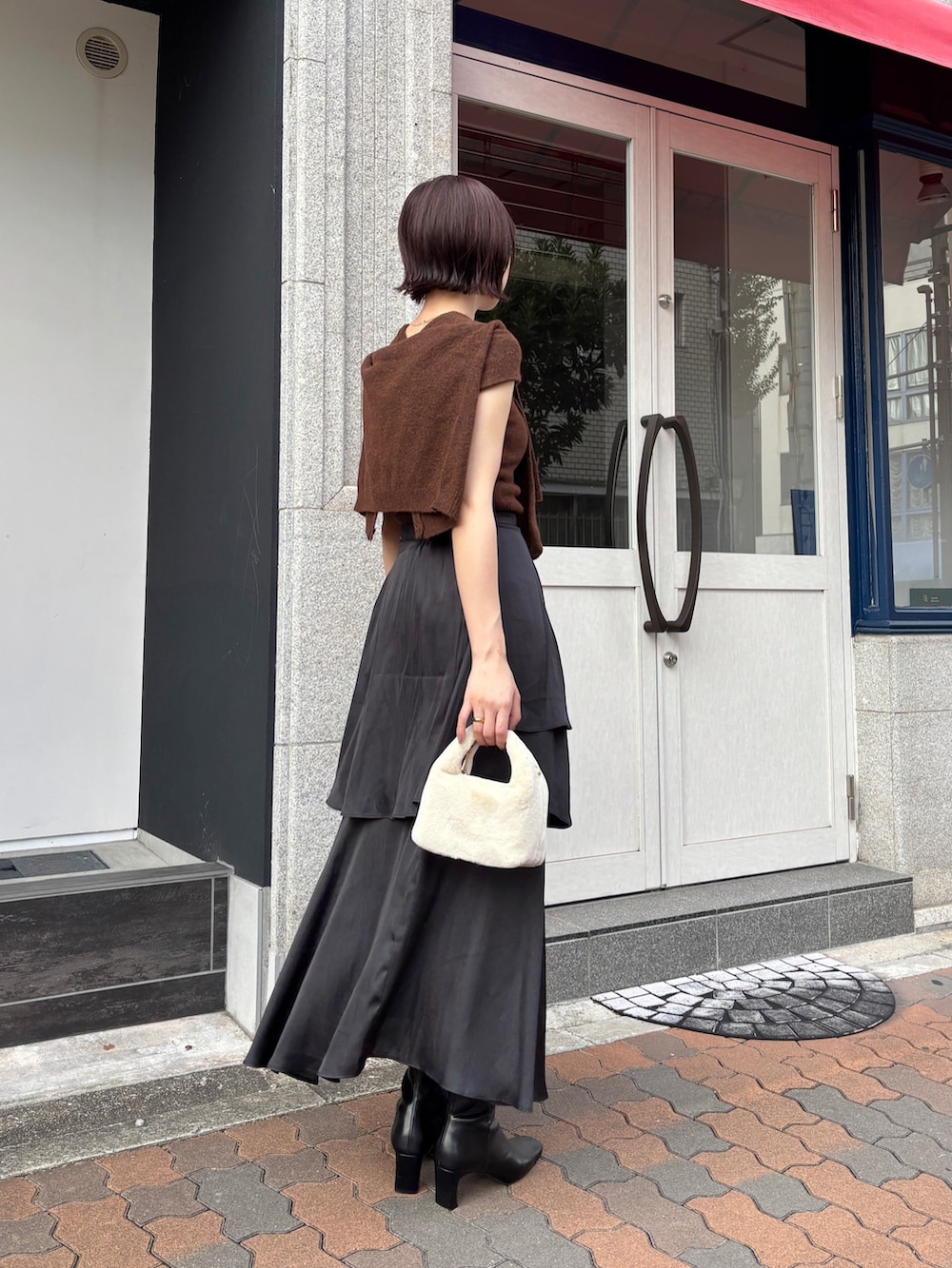 ブラック系のスカート、ブラウン系のアンサンブル、ブラック系のブーツを着用したレディースの秋コーディネートの7枚目の写真