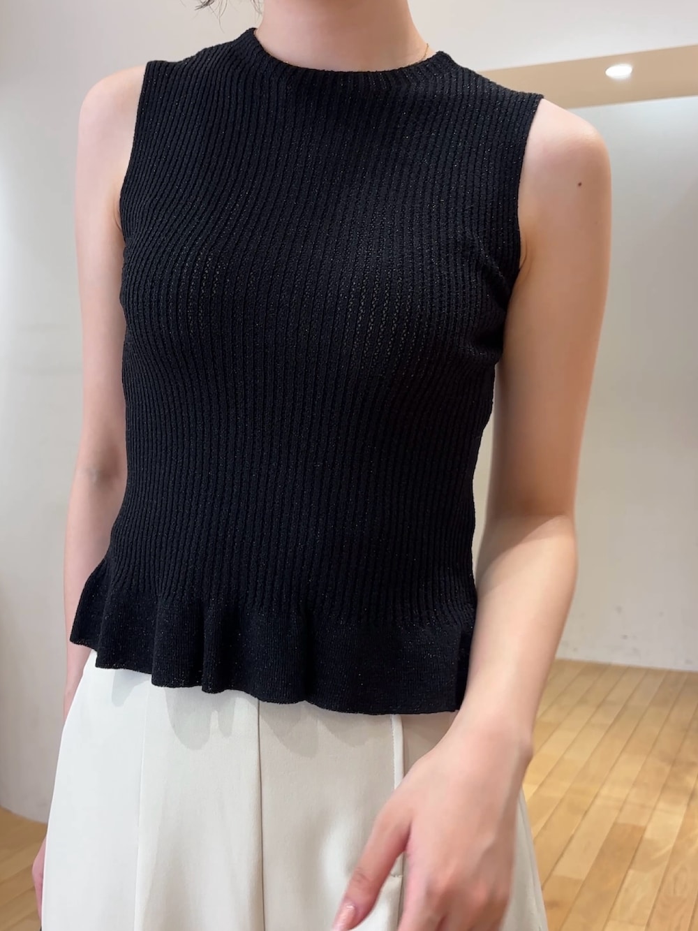 ブラック系のニット/セーター、ブラック系のカーディガン/ボレロ、ブラック系のハンドバッグを着用したレディースの夏コーディネートの4枚目の写真
