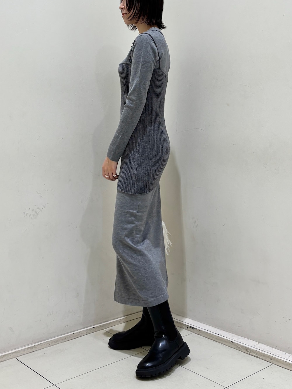 グレー系のワンピース、ホワイト系のハンドバッグを着用したレディースの冬コーディネートの3枚目の写真