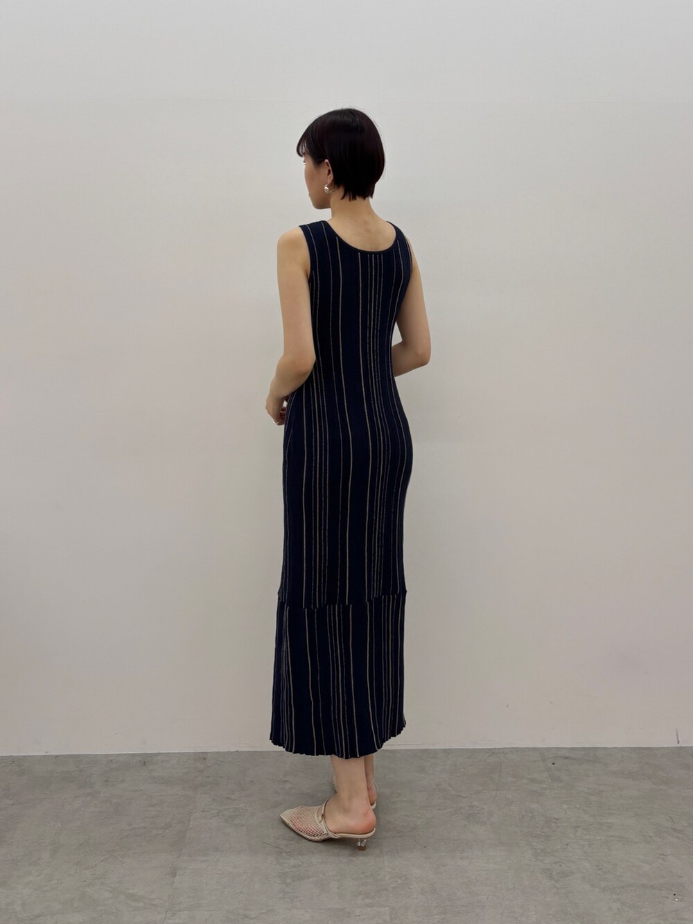 ブルー系のワンピース、ホワイト系のサンダル、シルバー系のピアス（両耳用）を着用したレディースの春コーディネートの4枚目の写真