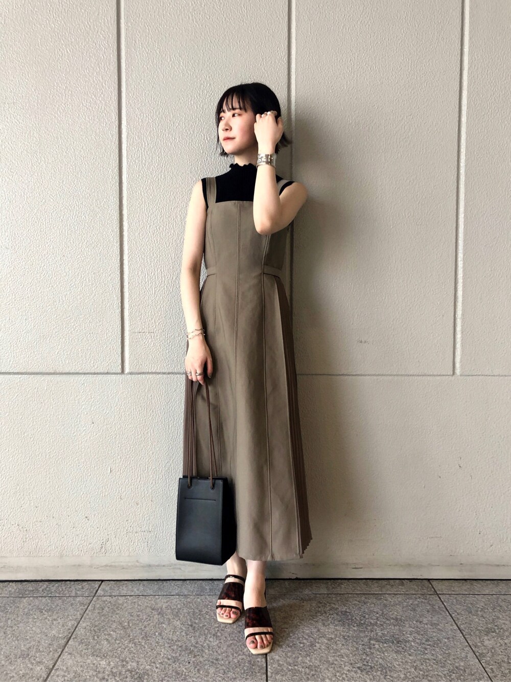 ベージュ系のワンピース、その他のその他シューズ、ブラック系のニット/セーターを着用したレディースの春コーディネートの2枚目の写真