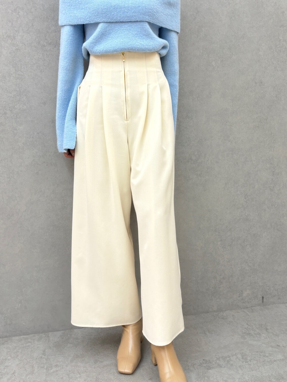 ブルー系のニット/セーター、ホワイト系のその他パンツを着用したレディースの秋コーディネートの7枚目の写真