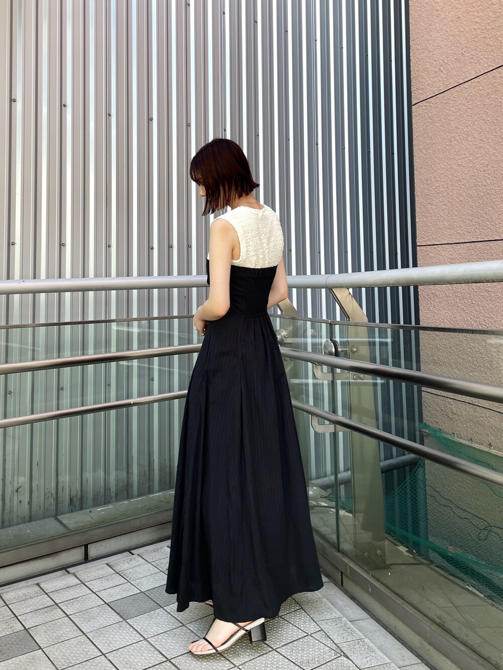 ブラック系のサンダル、ブラック系のワンピースを着用したレディースの夏コーディネートの3枚目の写真