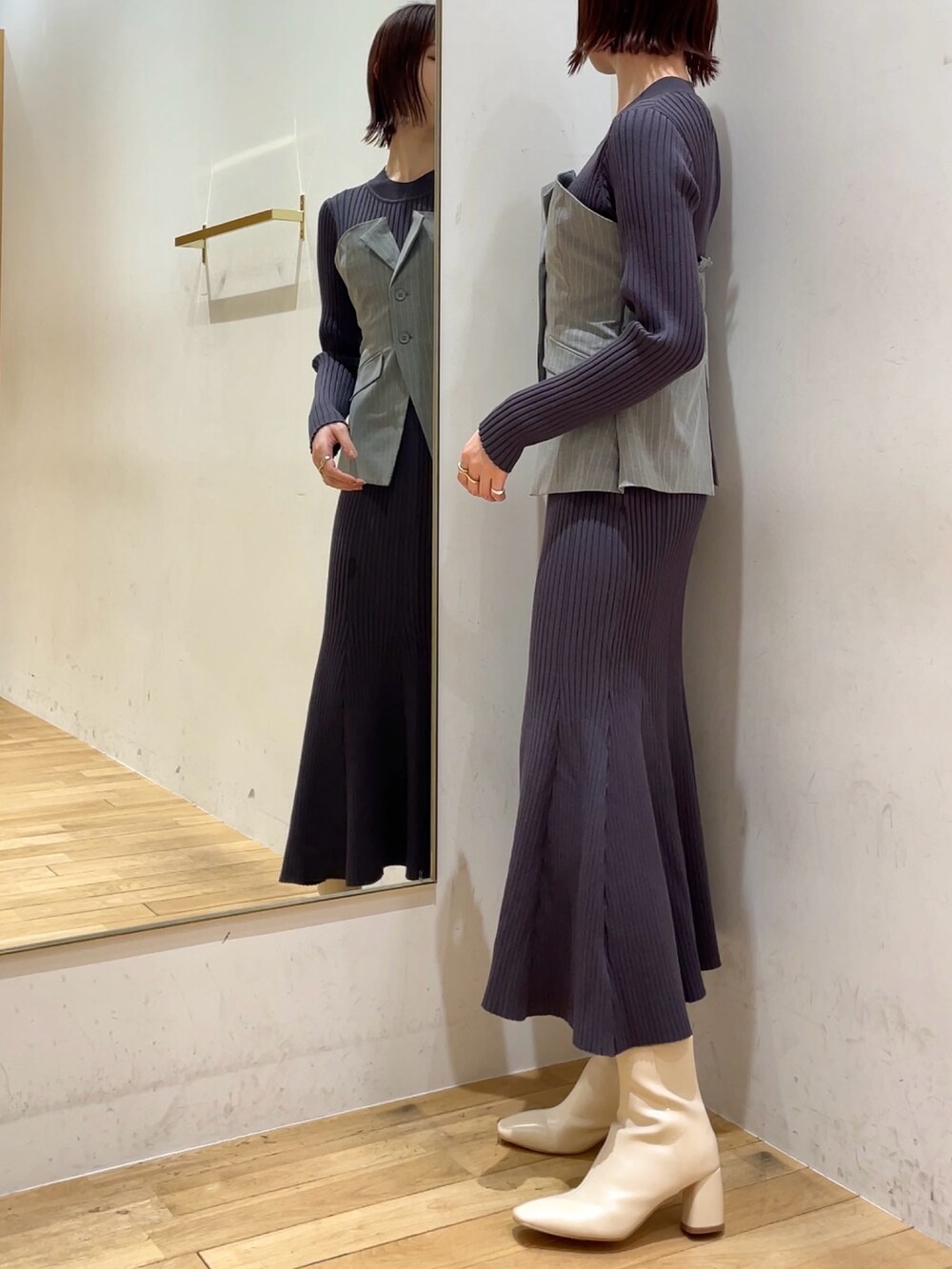 ホワイト系のブーツ、グレー系のワンピースを着用したレディースの冬コーディネートの4枚目の写真