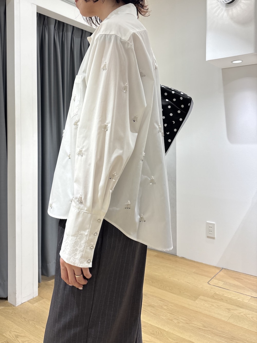 グレー系のその他パンツ、ホワイト系のシャツ/ブラウス、ブラック系のハンドバッグを着用したレディースの秋コーディネートの6枚目の写真