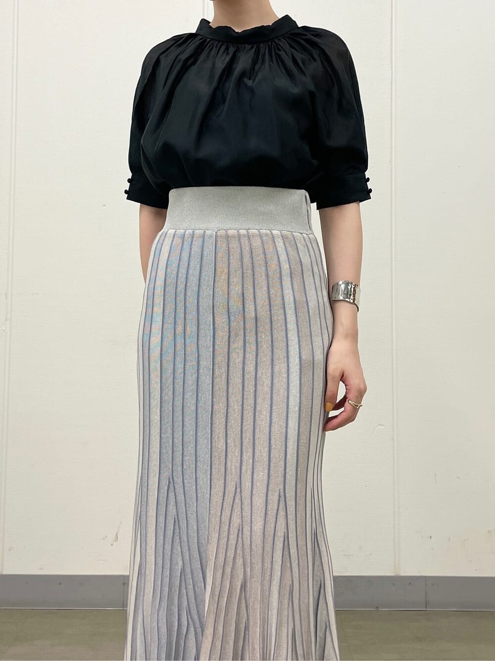 ブルー系のスカート、ホワイト系のサンダル、ブラック系のシャツ/ブラウスを着用したレディースの夏コーディネートの7枚目の写真