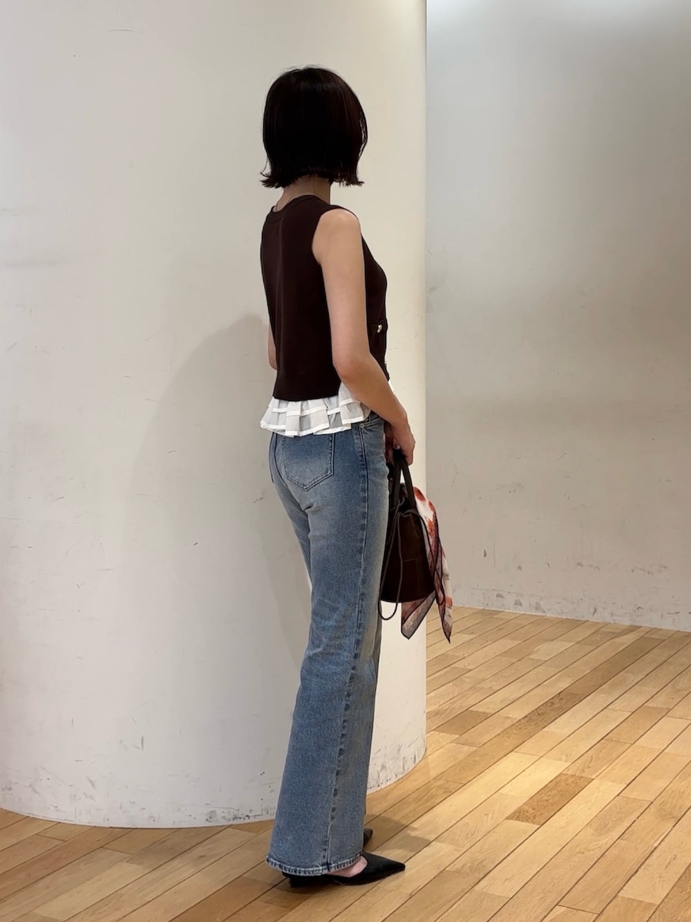 ブラウン系のニット/セーター、ブルー系のデニムパンツ、ブラック系のパンプスを着用したレディースの夏コーディネートの2枚目の写真