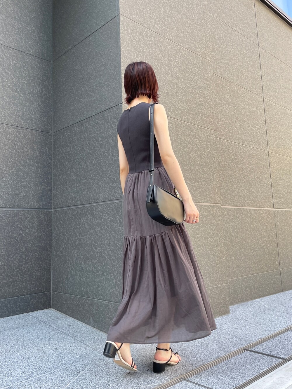 ブラック系のサンダル、グレー系のワンピース、ブラック系のショルダーバッグを着用したレディースの夏コーディネートの4枚目の写真