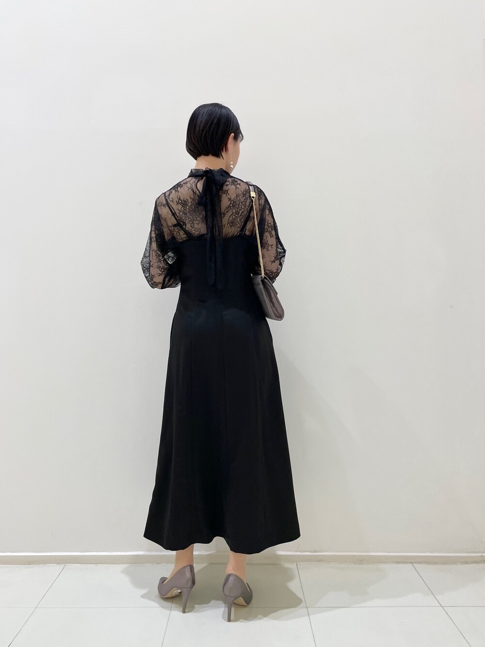 ブラック系のドレス、シルバー系のパンプス、シルバー系のハンドバッグを着用したレディースの春コーディネートの8枚目の写真