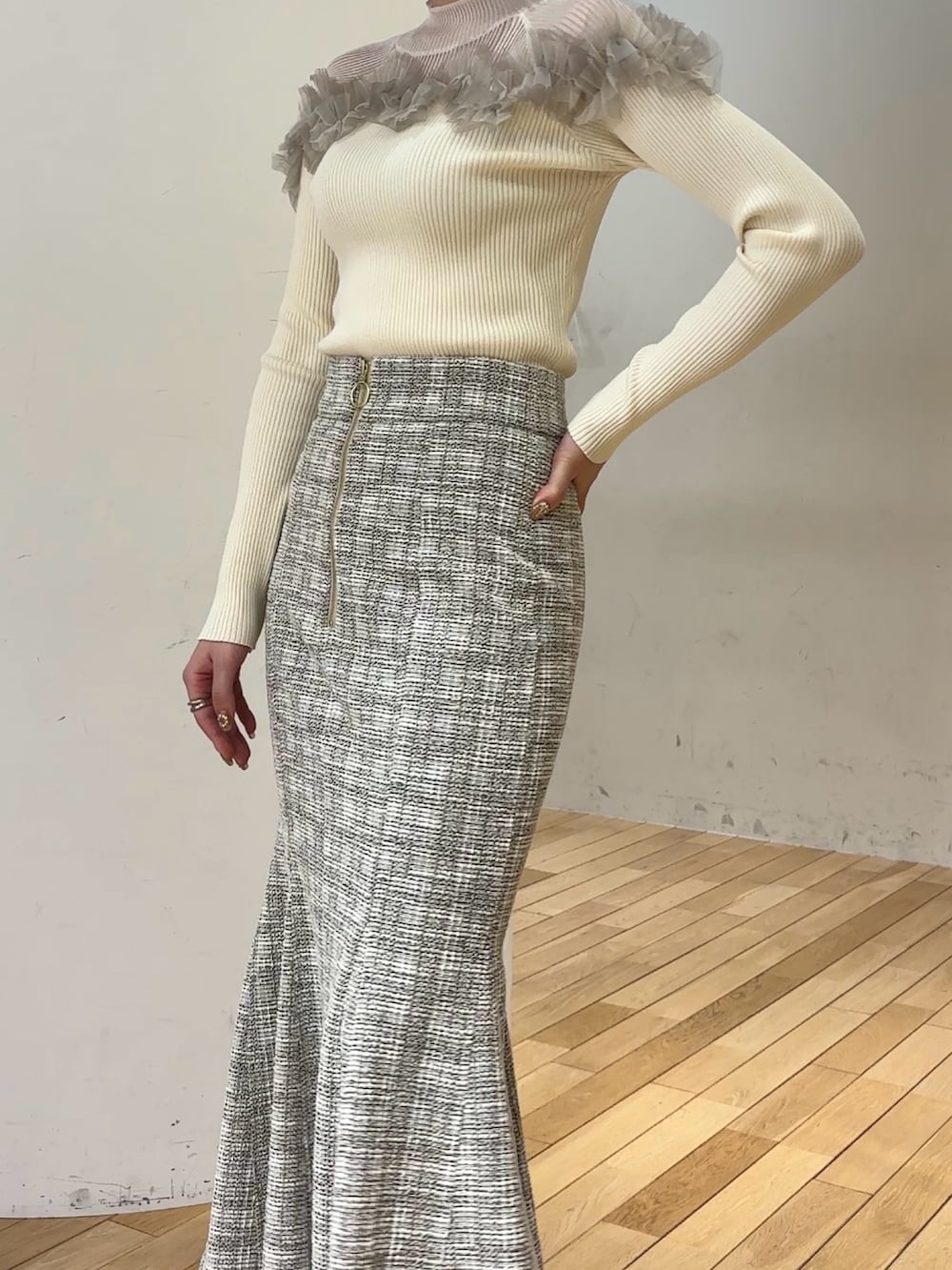 ブラック系のブーツ、ホワイト系のニット/セーター、ホワイト系のスカートを着用したレディースの冬コーディネートの6枚目の写真