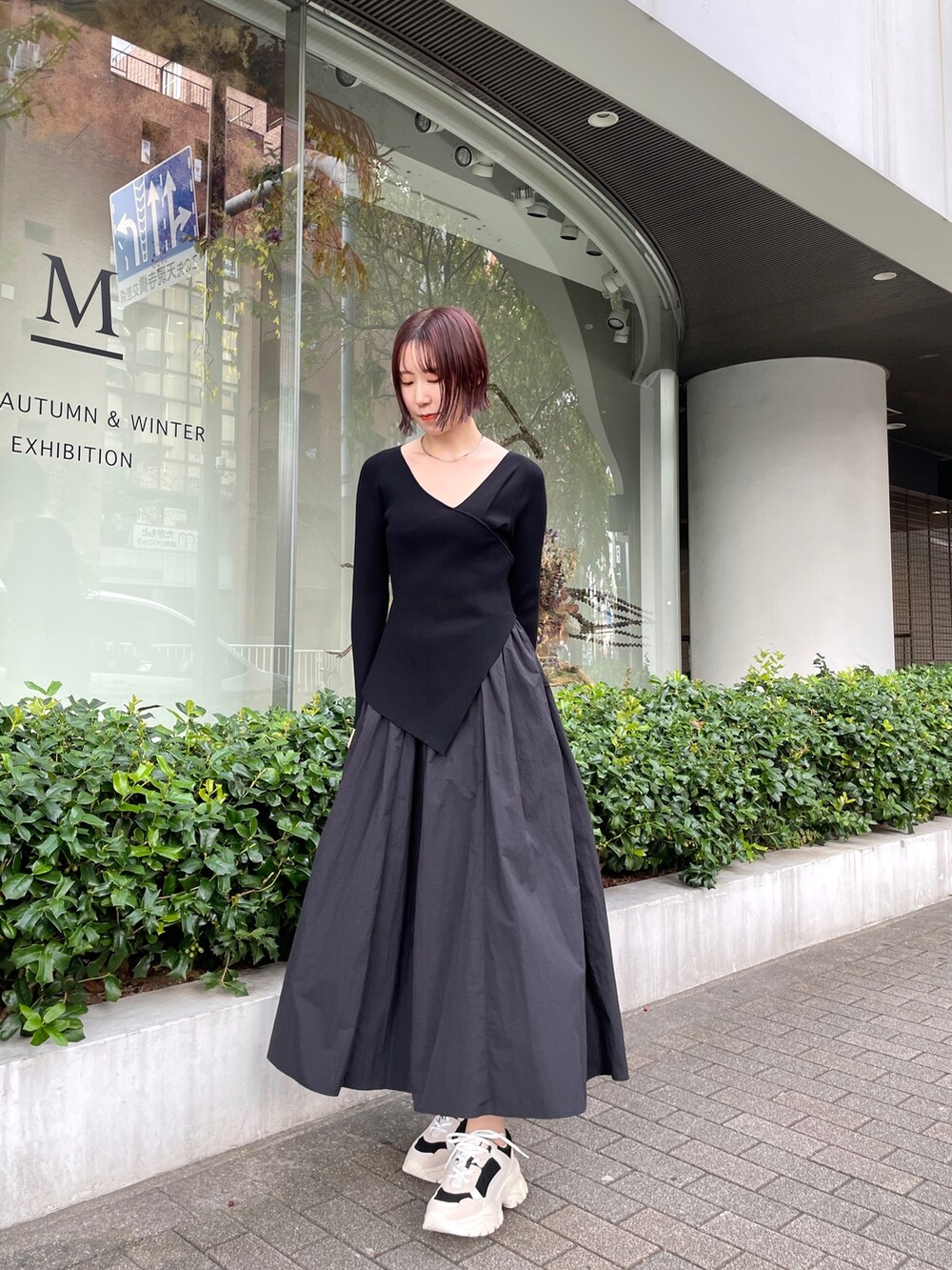 ブラック系のスニーカー、ブラック系のワンピースを着用したレディースの冬コーディネートの2枚目の写真