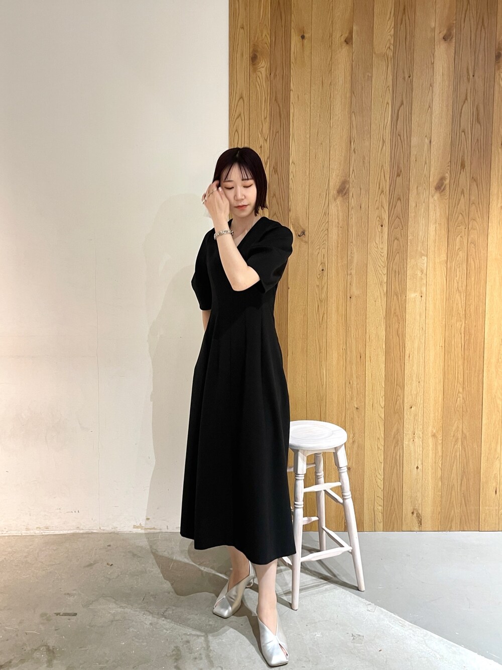 シルバー系のパンプス、ブラック系のワンピースを着用したレディースの春コーディネートの2枚目の写真