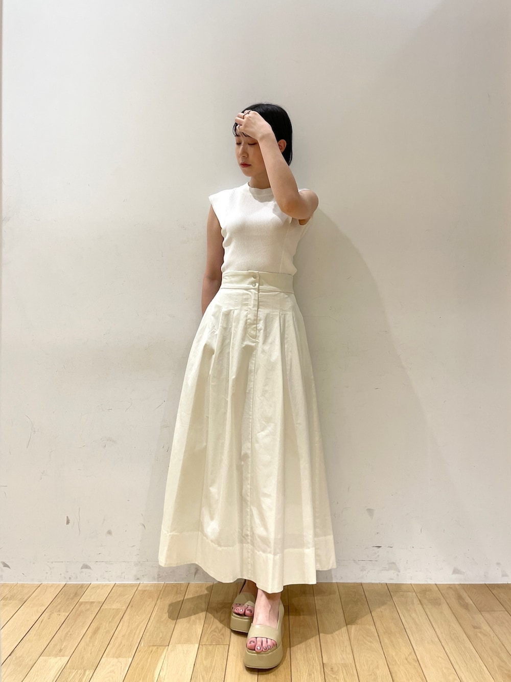 ホワイト系のニット/セーター、ホワイト系のスカート、ホワイト系のハンドバッグを着用したレディースの夏コーディネートの5枚目の写真