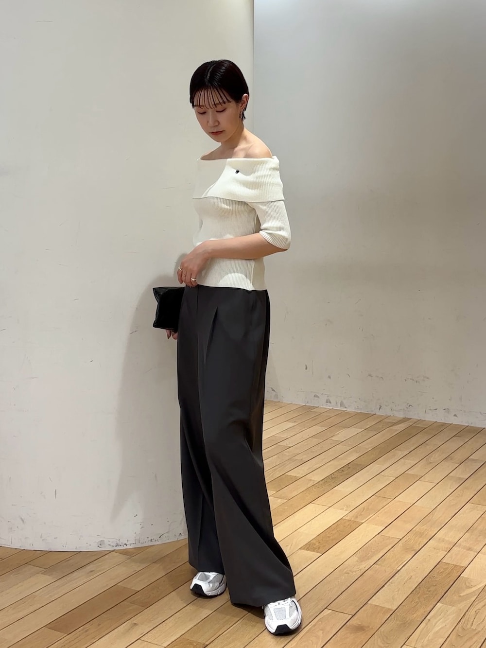 グレー系のその他パンツ、ホワイト系のニット/セーターを着用したレディースの春コーディネートの2枚目の写真