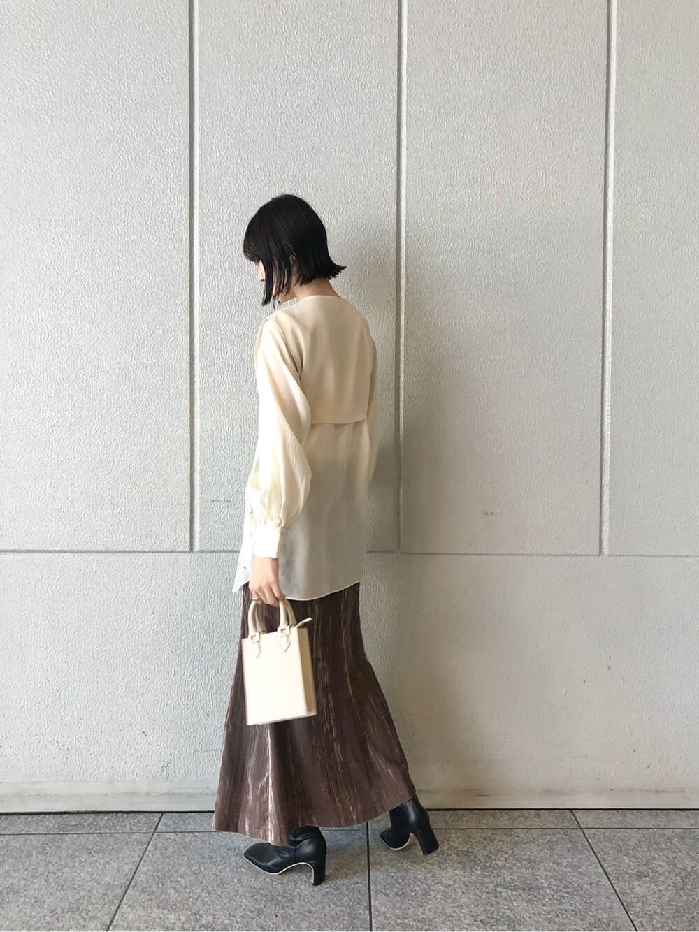 ベージュ系のスカート、ホワイト系のシャツ/ブラウス、ブラック系のその他シューズを着用したレディースの秋コーディネートの3枚目の写真
