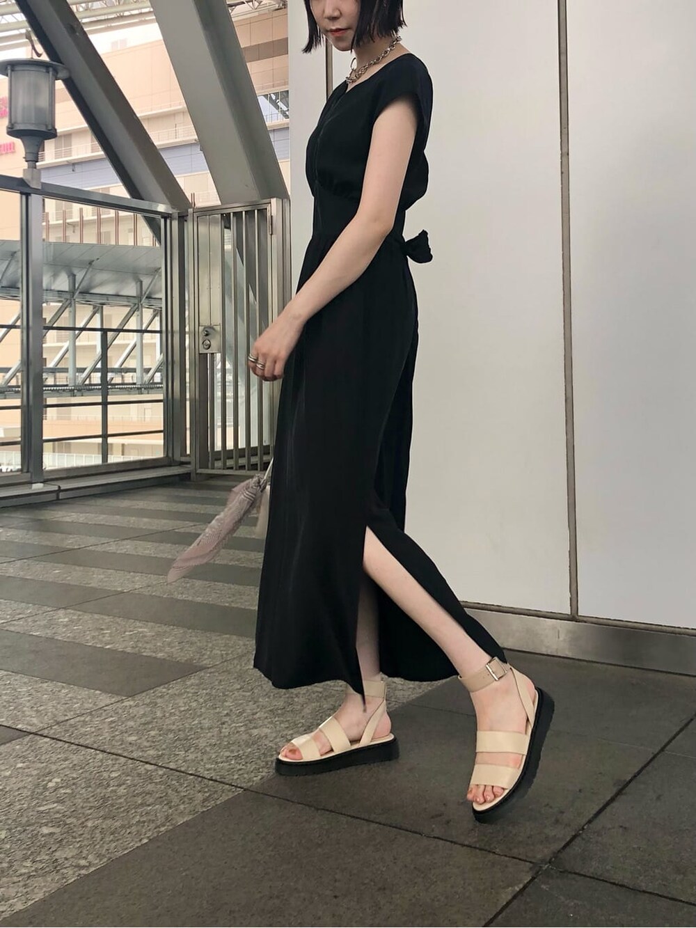 ホワイト系のショルダーバッグ、ブラック系のワンピース、ホワイト系のサンダルを着用したレディースの夏コーディネートの6枚目の写真