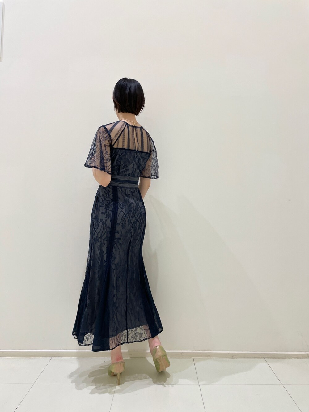 ブルー系のドレス、ゴールド系のパンプス、ホワイト系のネックレスを着用したレディースの春コーディネートの5枚目の写真