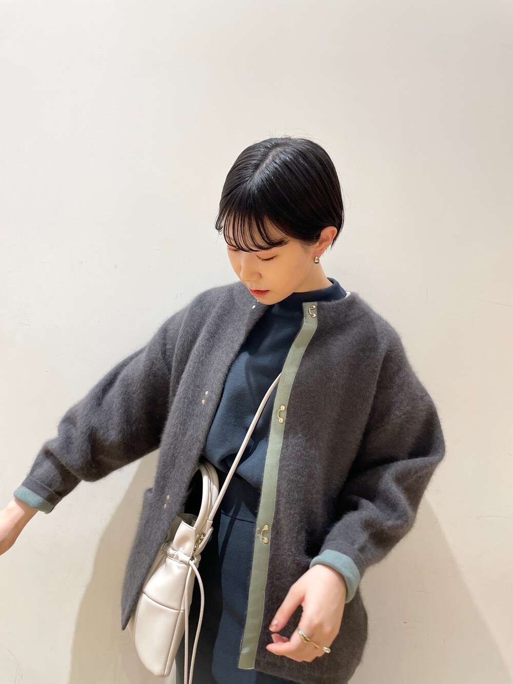 グレー系のカーディガン/ボレロ、グリーン系のニット/セーター、グリーン系のスカートを着用したレディースの冬コーディネートの7枚目の写真