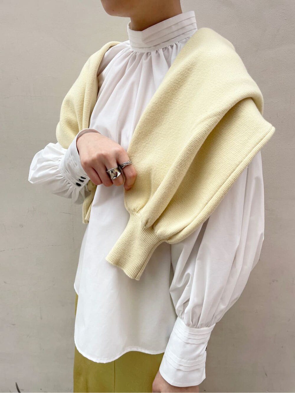 ホワイト系のシャツ/ブラウス、イエロー系のスカート、ベージュ系のハンドバッグを着用したレディースの冬コーディネートの5枚目の写真