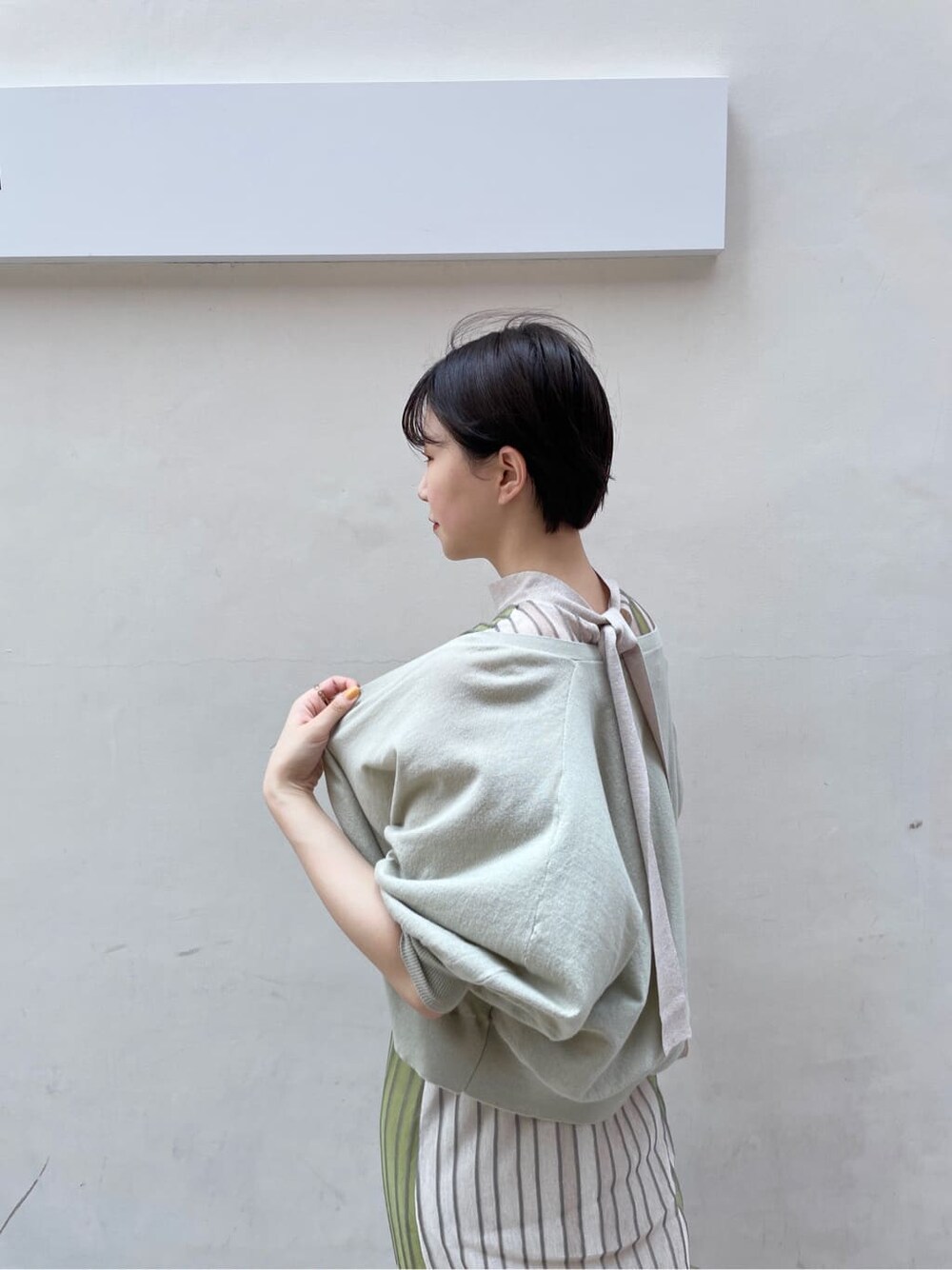 グリーン系のワンピース、グリーン系のカーディガン/ボレロ、ベージュ系のサンダルを着用したレディースの夏コーディネートの8枚目の写真