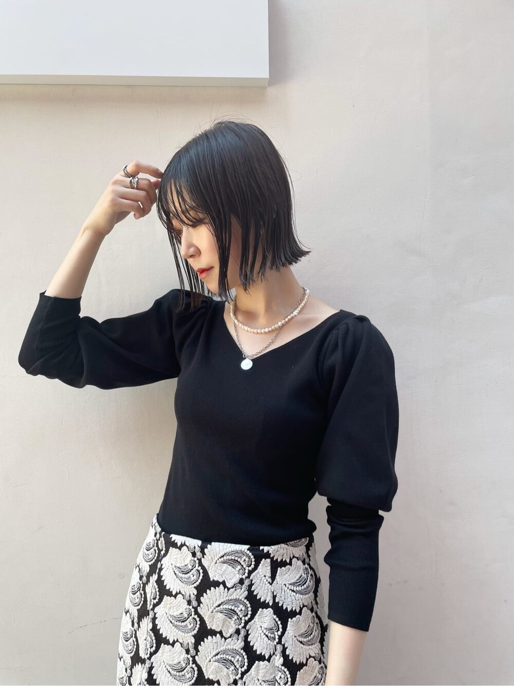 ブラック系のスカート、ブラウン系のショルダーバッグ、ホワイト系のその他シューズを着用したレディースの秋コーディネートの5枚目の写真