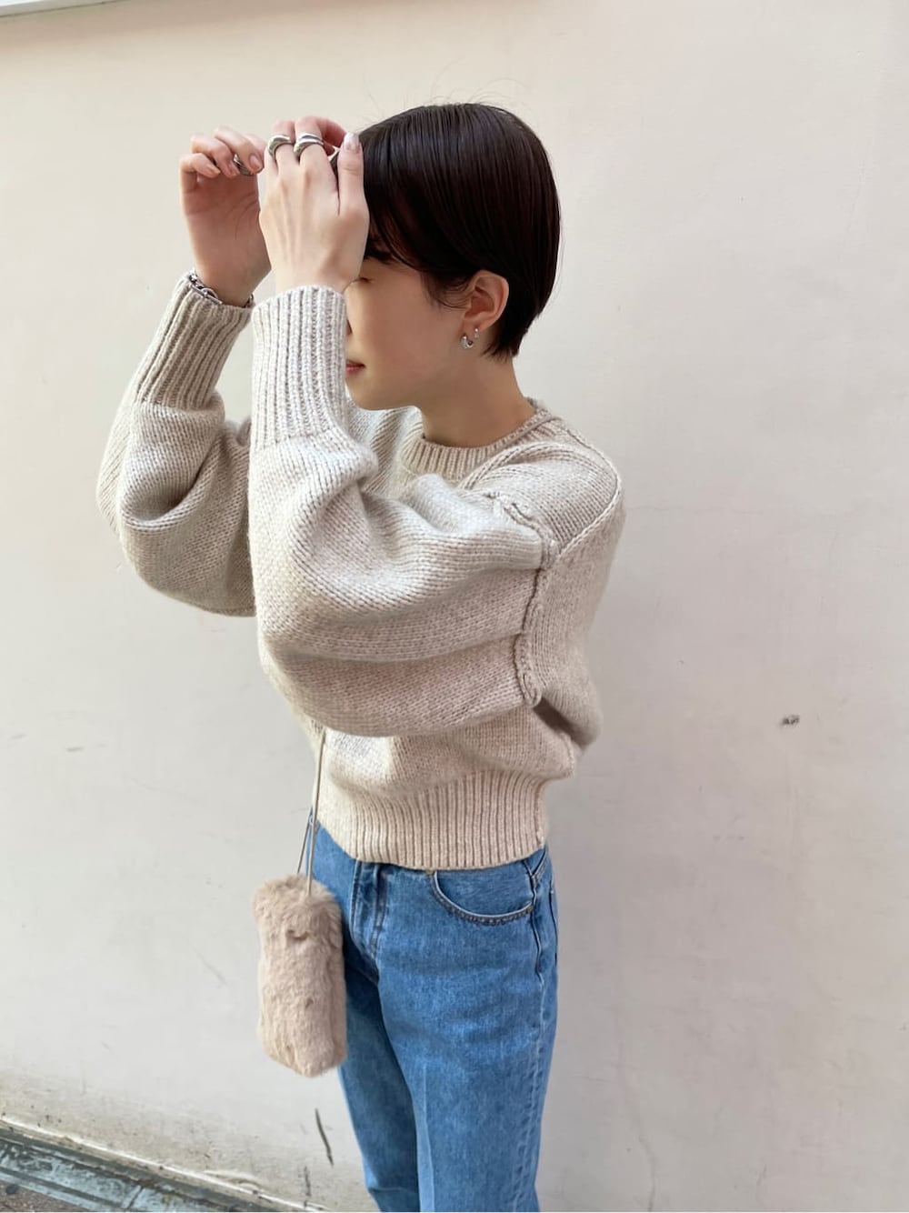 ブラック系のブーツ、ブルー系のデニムパンツ、ホワイト系のニット/セーターを着用したレディースの冬コーディネートの6枚目の写真