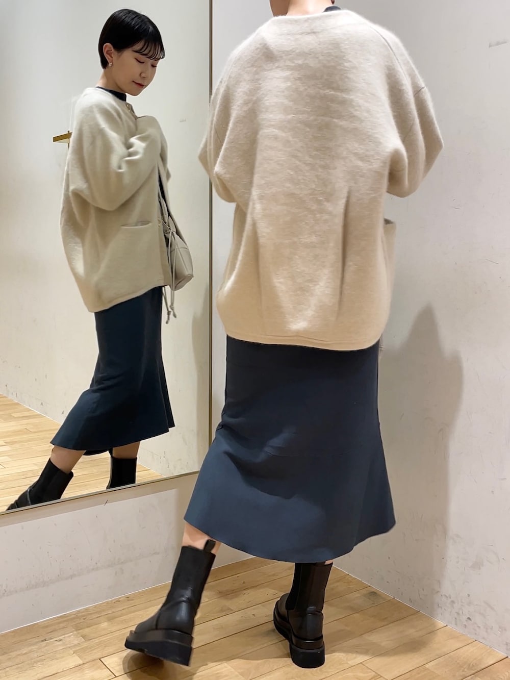 ホワイト系のカーディガン/ボレロ、グリーン系のスカート、グリーン系のニット/セーターを着用したレディースの冬コーディネートの3枚目の写真