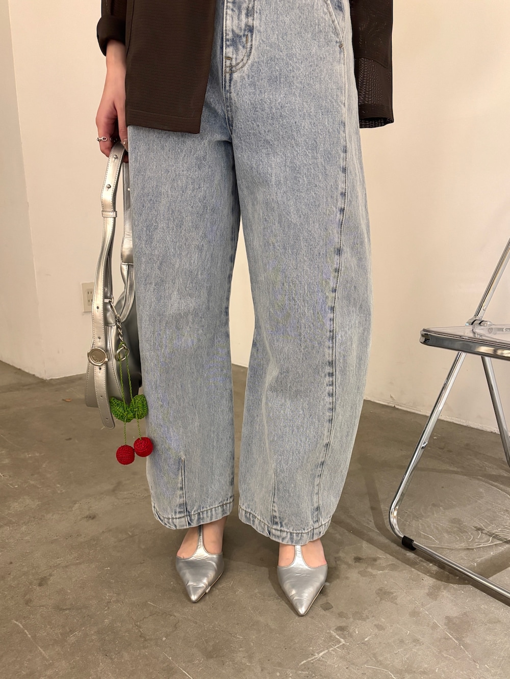 ブルー系のデニムパンツ、ブラウン系のテーラードジャケット、ブルー系のタンクトップを着用したレディースの春コーディネートの5枚目の写真