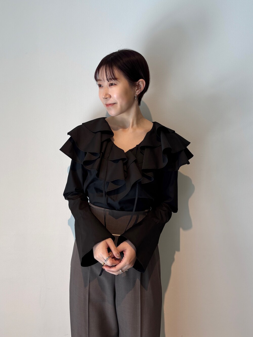 グレー系のスラックス、ブラック系のシャツ/ブラウス、ブラック系のサンダルを着用したレディースの春コーディネートの4枚目の写真