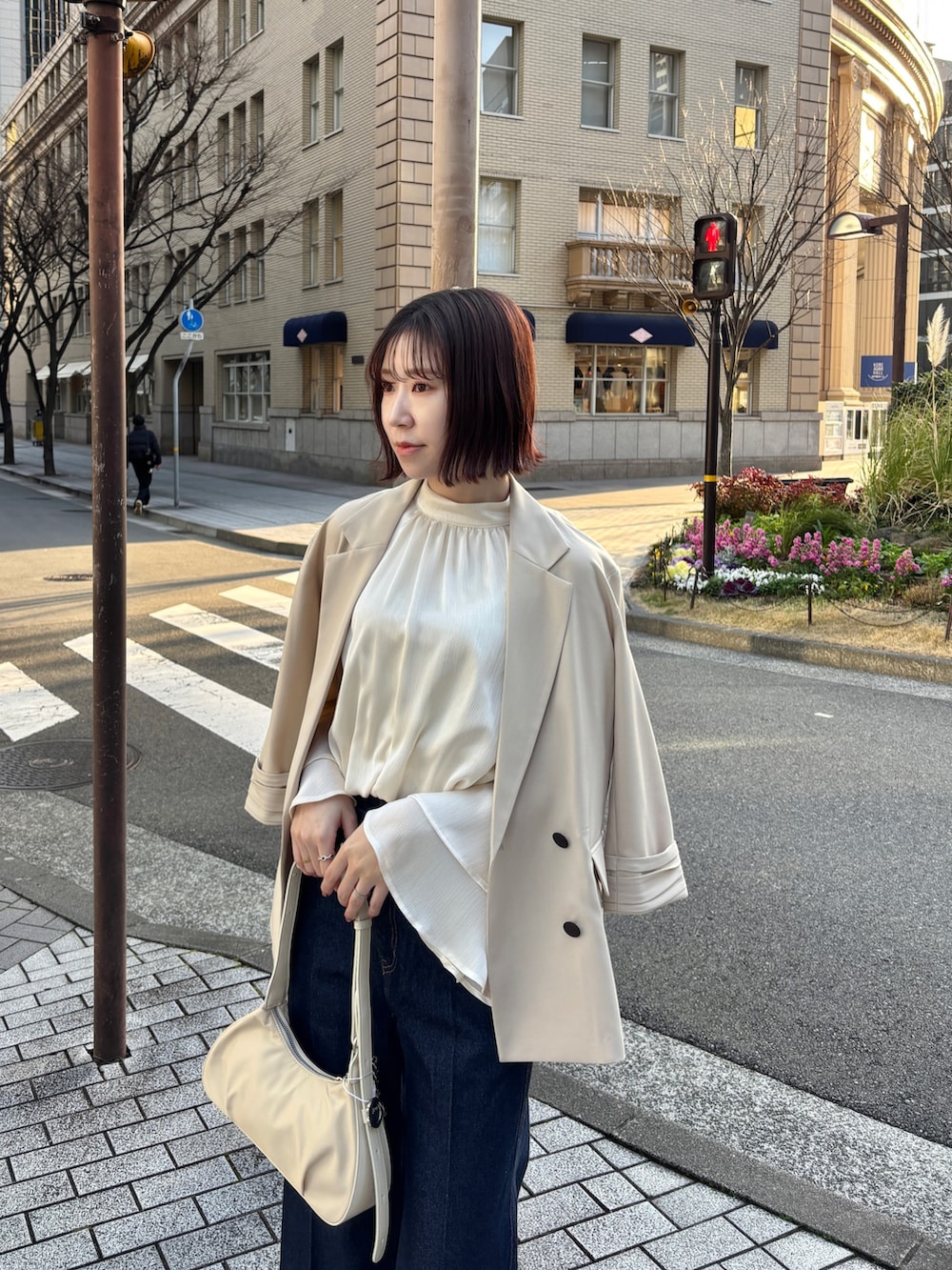 ホワイト系のシャツ/ブラウス、ホワイト系のハンドバッグ、ベージュ系のテーラードジャケットを着用したレディースの春コーディネートの7枚目の写真
