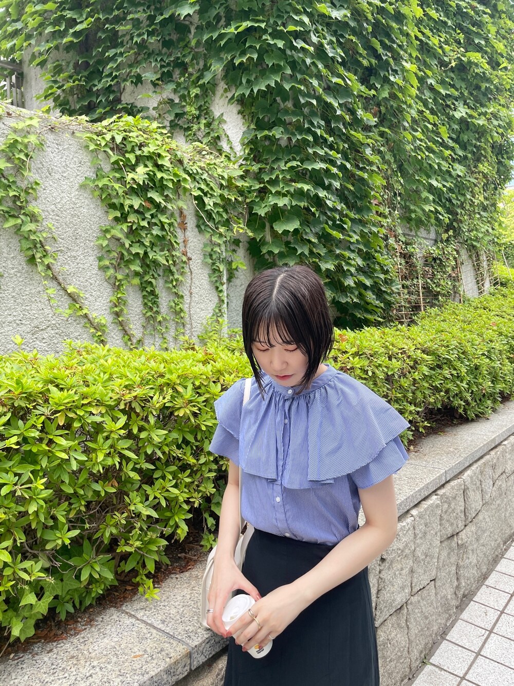 ホワイト系のショルダーバッグ、ブルー系のシャツ/ブラウス、ブラック系のスカートを着用したレディースの夏コーディネートの6枚目の写真