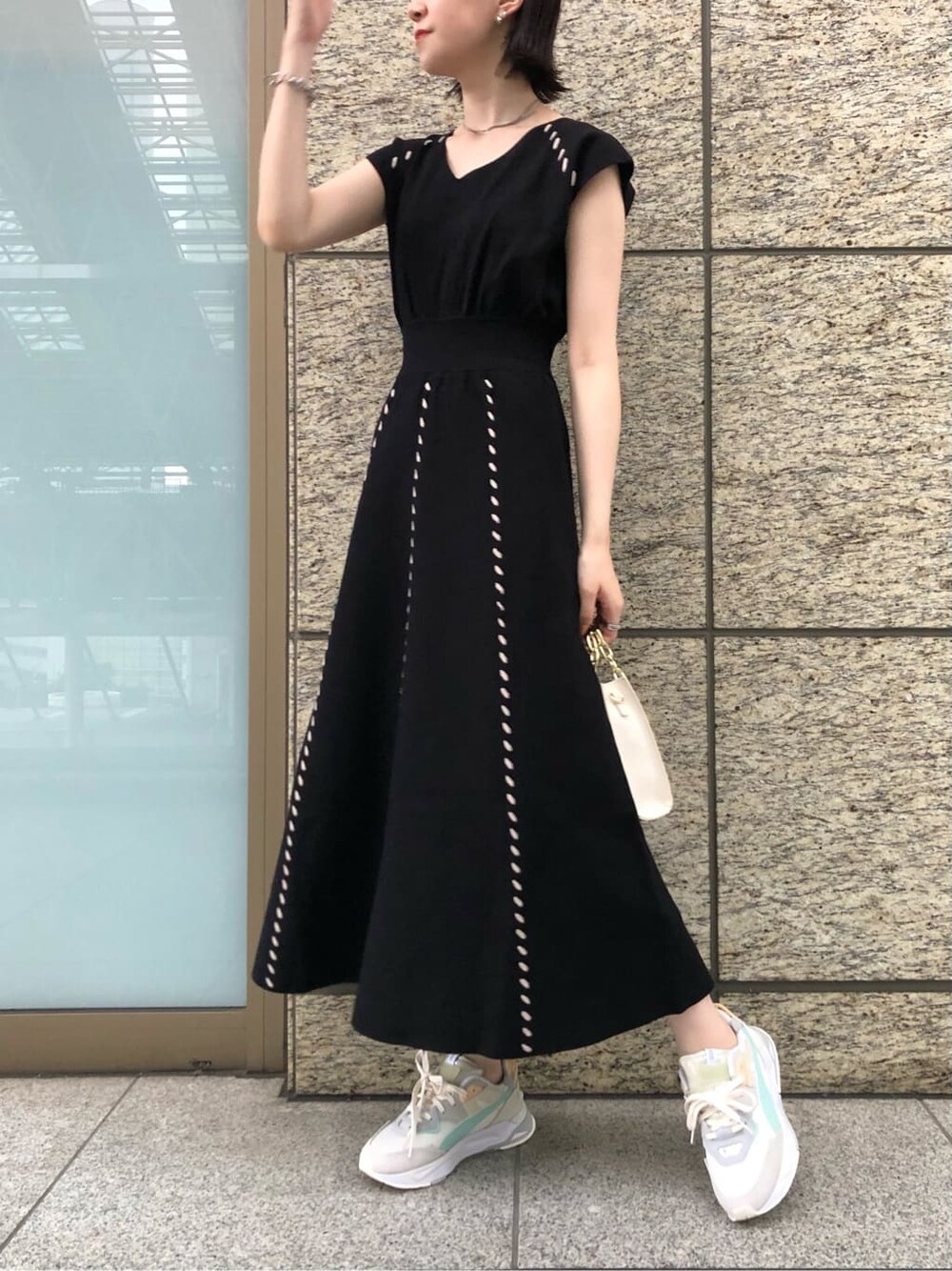 ブラック系のワンピース、ベージュ系のパンプス、ホワイト系のショルダーバッグを着用したレディースの夏コーディネートの6枚目の写真